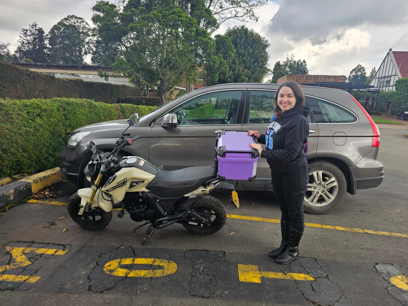 Mujer sonriendo junto a su motocicleta recién adquirida gracias a un préstamo de Coefra, representando el éxito y la realización de sus metas personales.